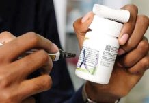 A staff member holds antiretroviral medication at TASO Mulago service center in Kampala, Uganda. GETTY IMAGES