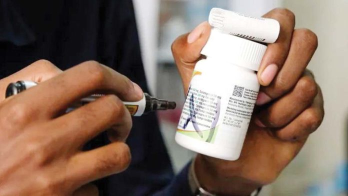 A staff member holds antiretroviral medication at TASO Mulago service center in Kampala, Uganda. GETTY IMAGES