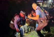 Rescue teams work in the dark, helping survivors walk up a rocky terrain in Honduras. REUTERS