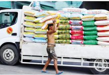 A worker unloads a sack of imported rice from a truck in Tondo, Manila. The public can expect a reduction in the retail prices of rice and pork in the coming days, according to the Presidential Communications Office. PNA