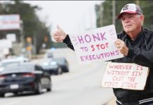 An anti-death penalty protester holds signs in South Carolina, USA.