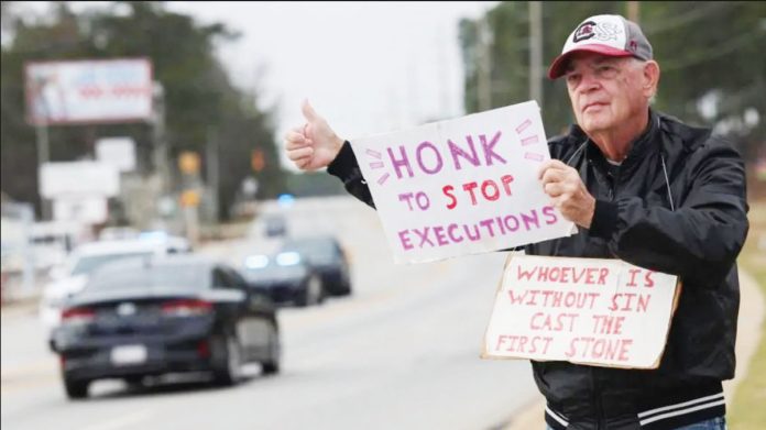 An anti-death penalty protester holds signs in South Carolina, USA.