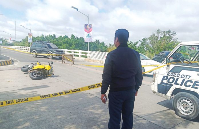 A police officer secures the spot where motorcycle-driving businessman Delfin Britanico was shot to death in Barangay Nabitasan, La Paz, Iloilo City on Jan. 19. 2020. PN FILE