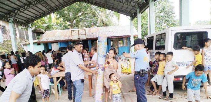 Officers of the Toboso Municipal Station led by assistant chief, Police Captain Armel L. Lasap, provide assistance and security during the distribution of relief goods to evacuees affected by the armed conflict in Barangay General Luna, Toboso, Negros Occidental, on March 19, 2025. TOBOSO MPS PHOTO