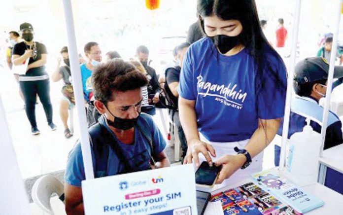 The National Telecommunications Commission is looking into requiring personal appearance for SIM card registration. Photo shows a staff member of a telecommunications firm helping a client register his SIM card. PNA PHOTO BY BEN BRIONES