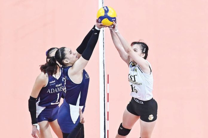 Negrense Cassie Carballo of the University of Santo Tomas Golden Tigresses and Jen Villegas of the Adamson University Lady Bulldogs joust for the ball on top of the net. UAAP PHOTO