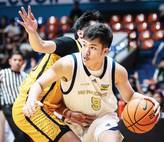 Ilonggo Chad Cartel of the National University Nazareth School Bullpups tries to ward off a University of Santo Tomas Tiger Cubs' defender. UAAP PHOTO