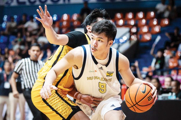 Ilonggo Chad Cartel of the National University Nazareth School Bullpups tries to ward off a University of Santo Tomas Tiger Cubs' defender. UAAP PHOTO