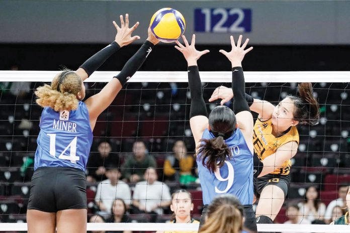 Far Eastern University Lady Tamaraws’ Gerzel Petallo hammers the ball towards the defense of Ateneo de Manila University Blue Eagles’ Alexa Miner and Takako Fujimoto. UAAP PHOTO