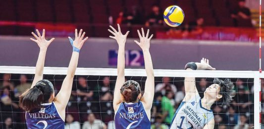 National University Lady Bulldogs’ Alyssa Solomon smashes the ball against the defense of Adamson University Lady Falcons. UAAP PHOTO