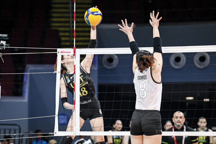 University of Santo Tomas Golden Tigresses’ Regina Jurado avoids the defense of Bacolodnon Joan Marie Monares of the University of the Philippines Fighting Maroons for a drop ball. UAAP PHOTO