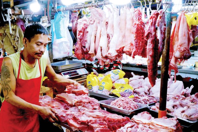 A butcher arranges various pork cuts at a stall inside the Kamuning Market, Quezon City. The Department of Agriculture is set to implement a maximum suggested retail price for pork this March as prices remain high. PNA PHOTO BY BEN BRIONES